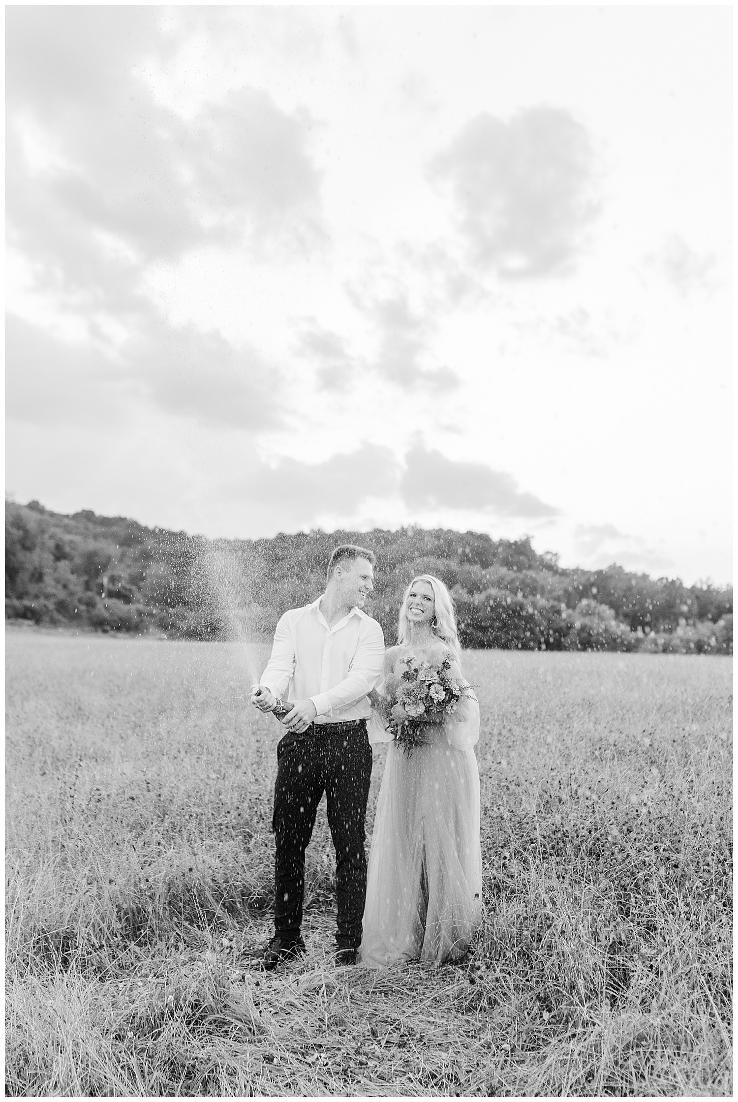 Abigail and Jace popping champagne at their classic picnic engagement session in West Virginia