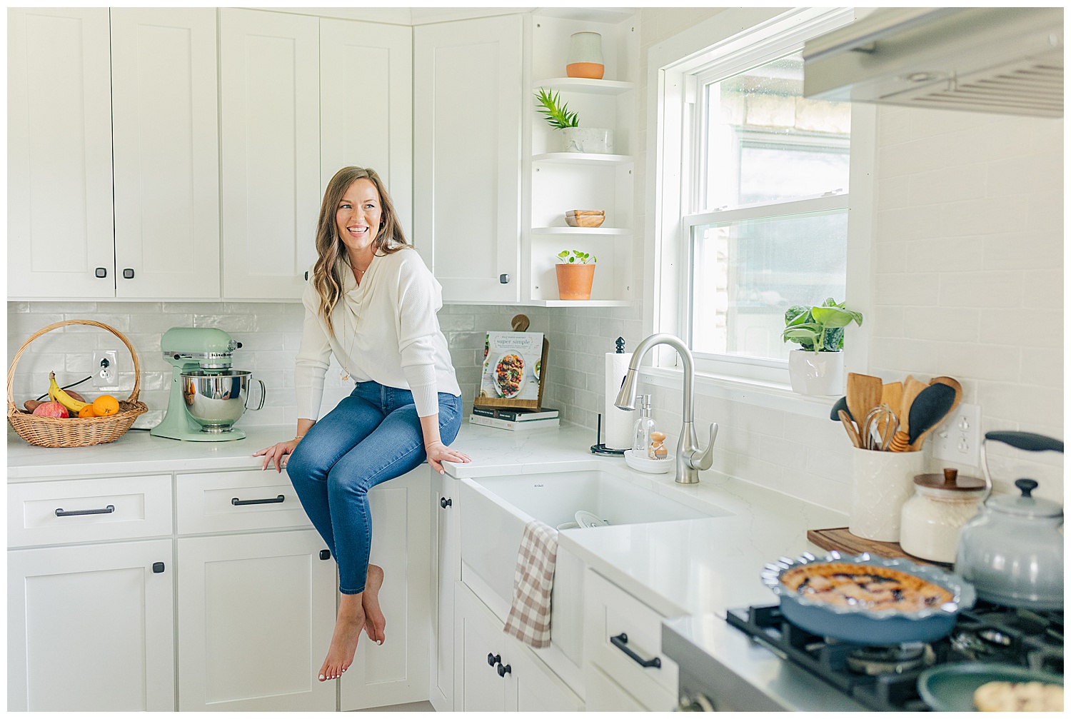 Amanda sitting on her kitchen counter at home, smiling warmly during her Sweet Home Vanilla branding session in Thomas, West Virginia.