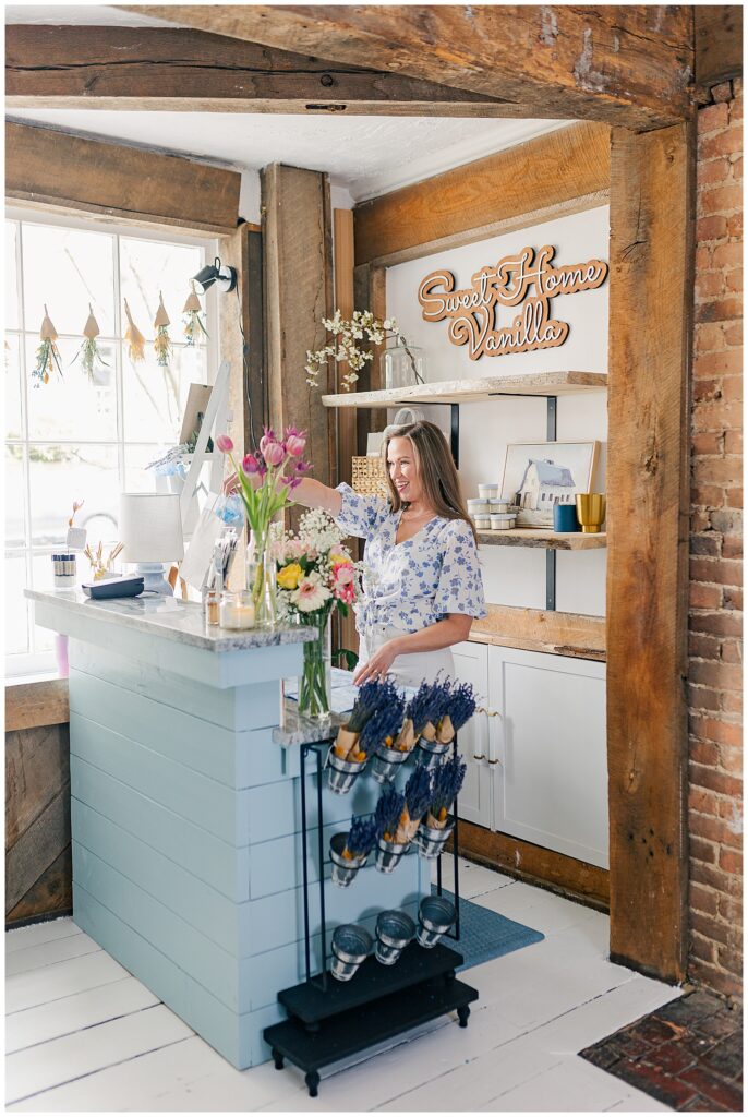 Amanda standing inside her Sweet Home Vanilla retail shop in Thomas, West Virginia, surrounded by her handmade products.