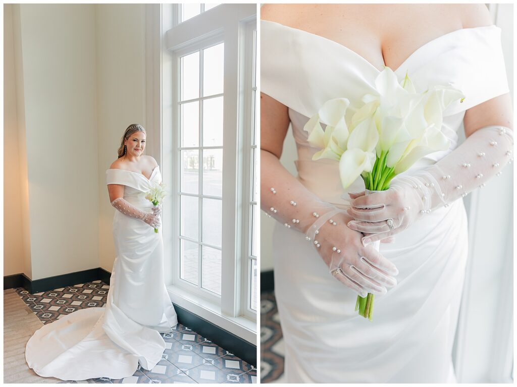 Bride standing by a large window at Hotel Morgan, holding a bouquet of white calla lilies and gazing out thoughtfully, showcasing her classic, elegant wedding gown.