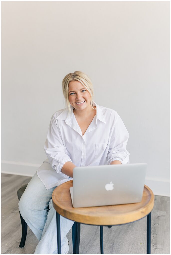 Morgan smiling while working on her laptop at 304 Collective, showcasing her workspace and planning process for event design projects.