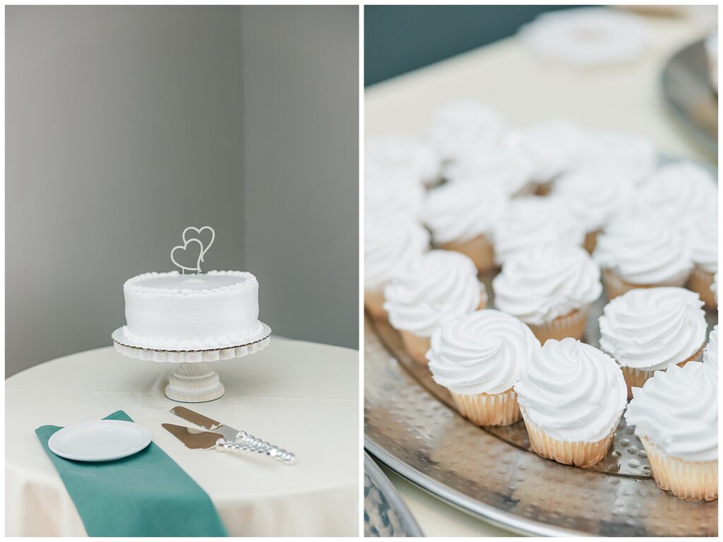 Close-up of the wedding cake and cupcakes on display at the reception, with a heart-shaped cake topper and teal accents.