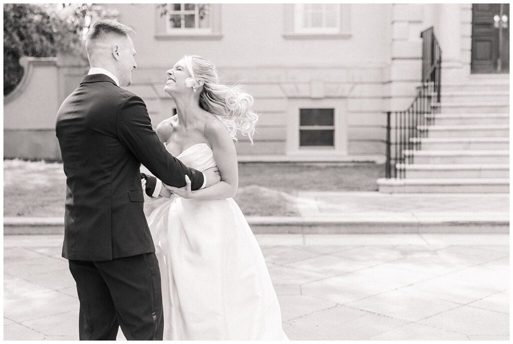 Bride laughs joyfully as she looks up at the groom, both caught in a candid, playful moment during their first look.
