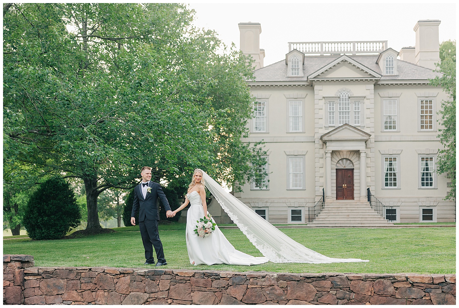 Bride and groom holding hands in front of elegant Great Marsh Estate during Virginia wedding, captured by Zoe Evans Photography