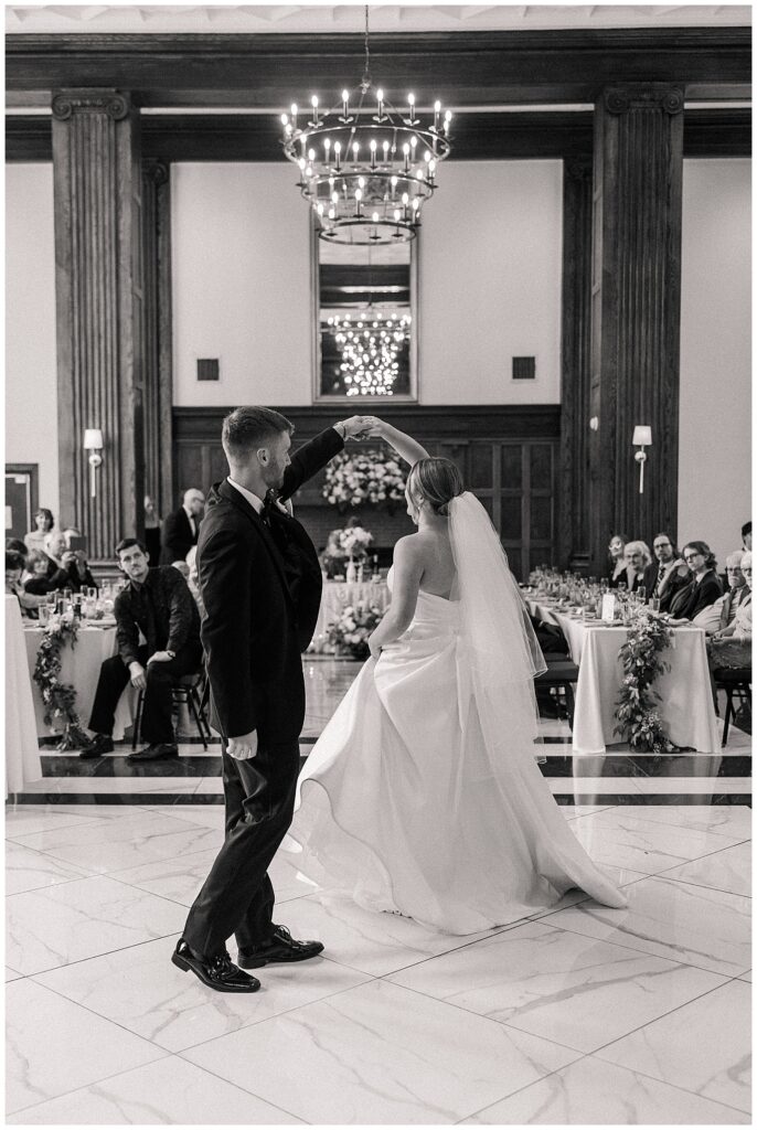 Black and white image of the bride walking down the aisle with the groom waiting at the altar inside Hotel Morgan’s elegant ceremony space.
