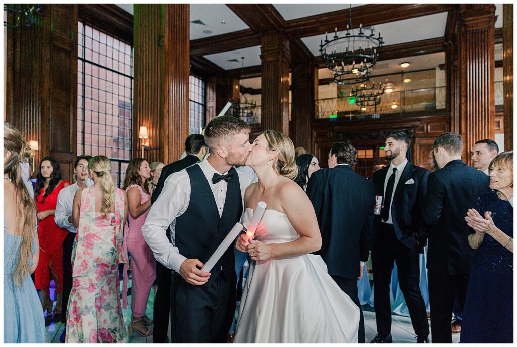 Bride and groom kiss on the dance floor during their reception at Hotel Morgan, surrounded by guests and celebration.