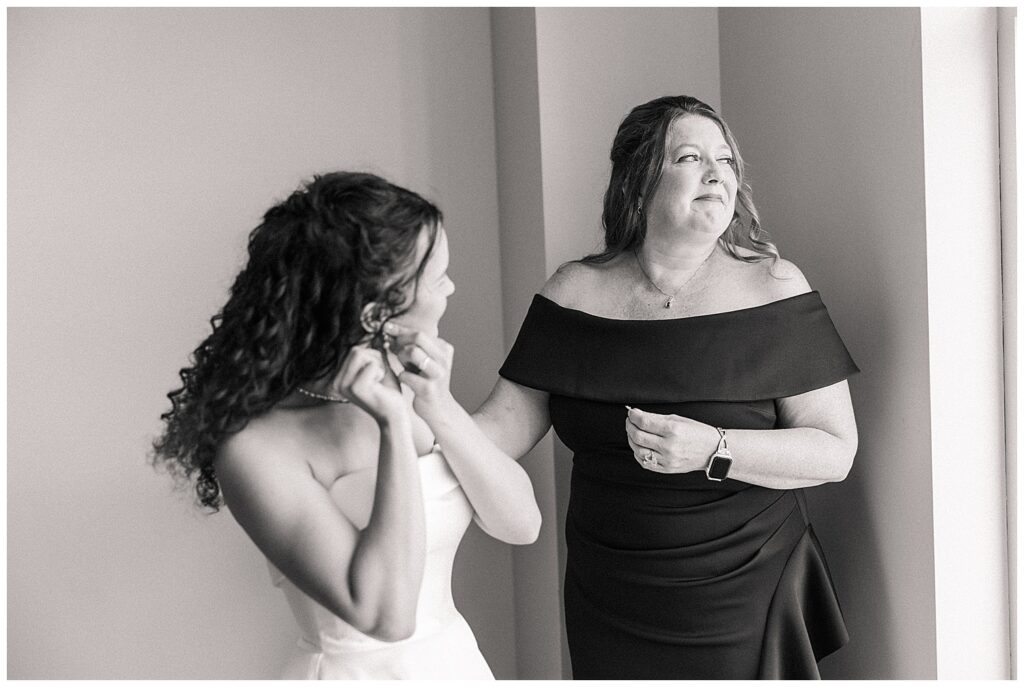Candid black and white photo of bride sharing a joyful moment with her mom while getting ready