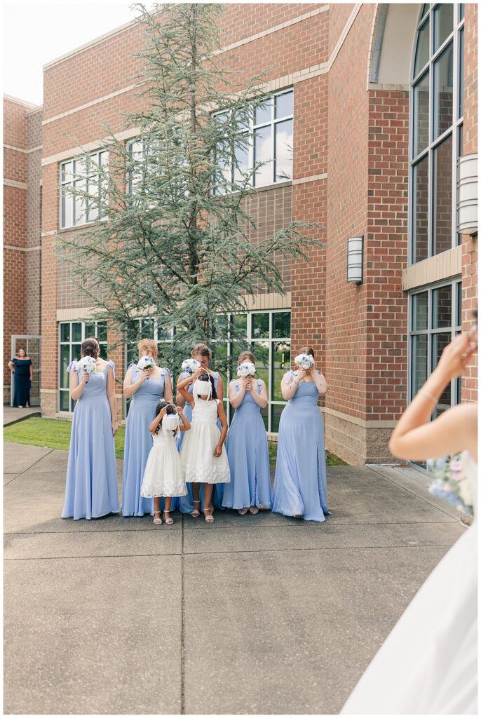 Bride’s bridal party wiping away tears during first look moment outside venue