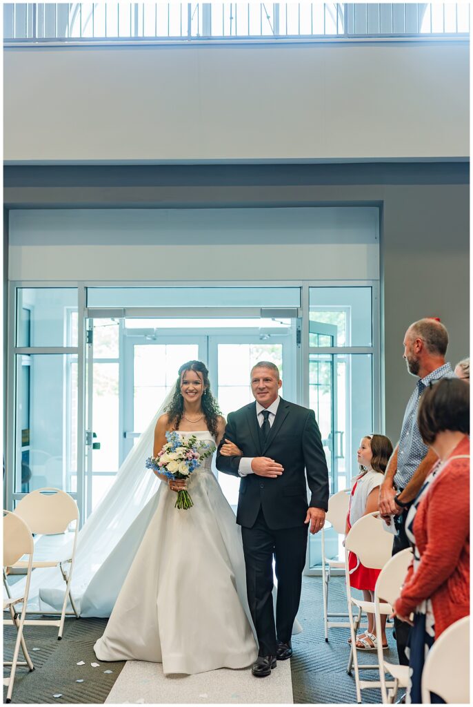 Bride walks down the aisle with her father during wedding ceremony — Zoe Evans Photography