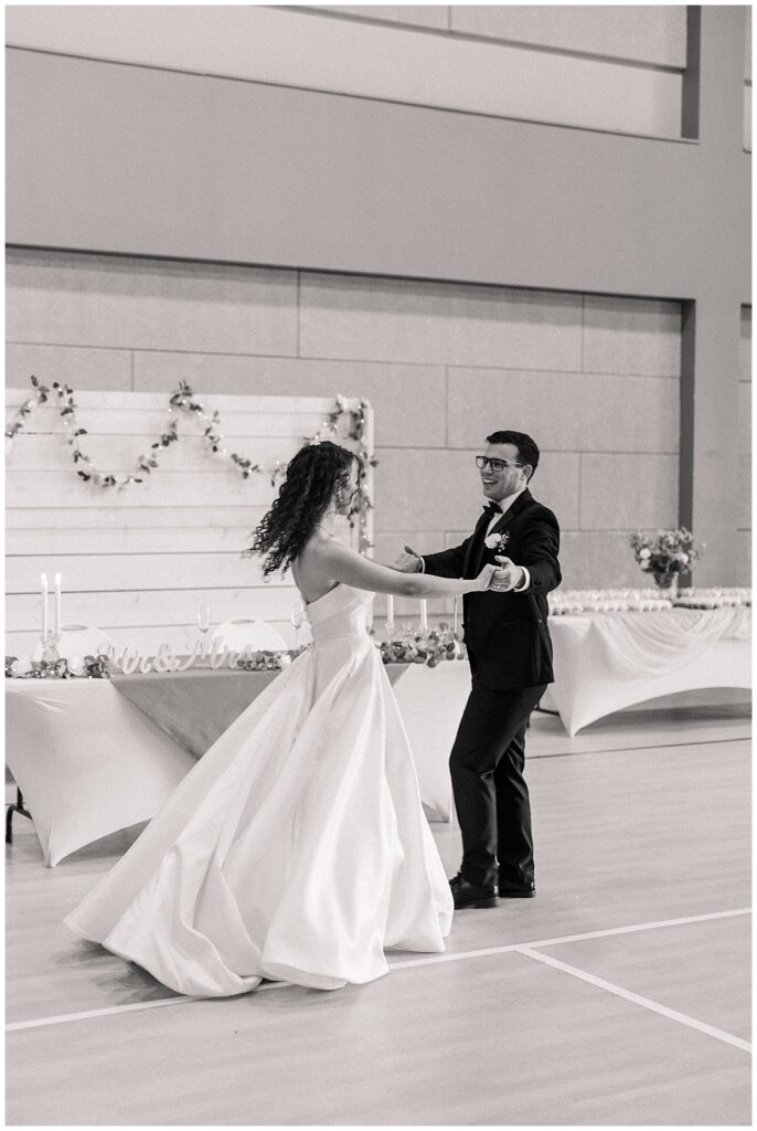 Black and white photo of bride and groom dancing near their sweetheart table — Zoe Evans Photography