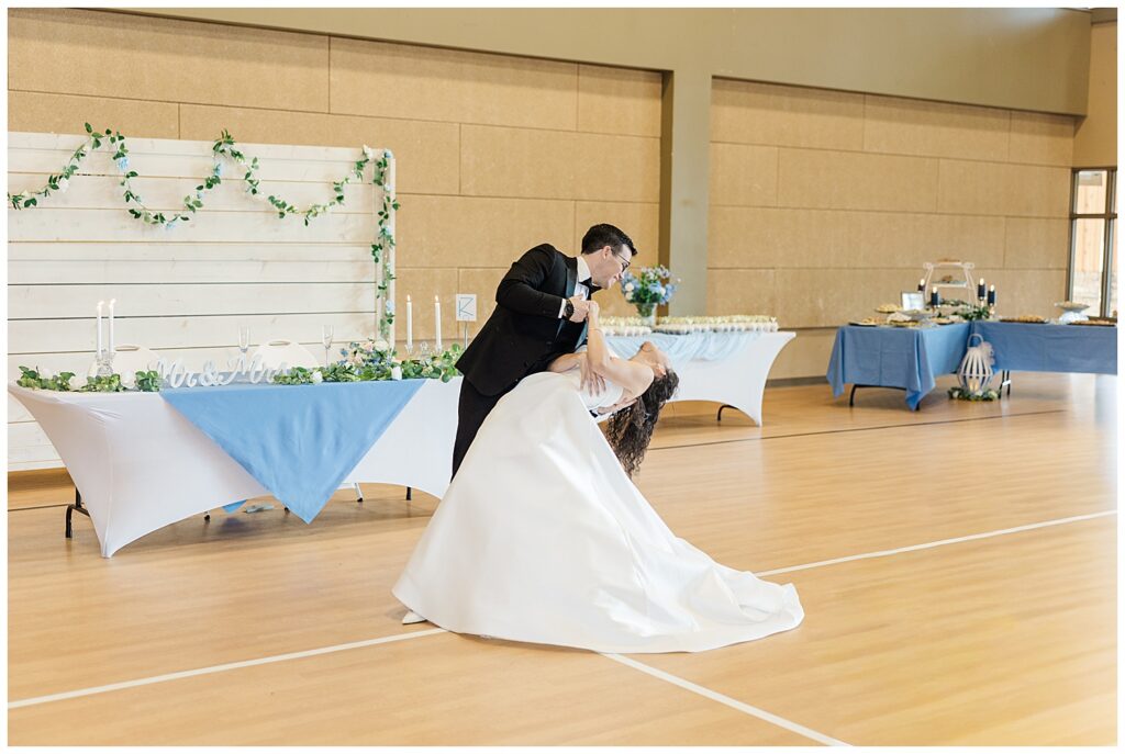 Romantic wedding reception dance dip surrounded by soft blue and white decor