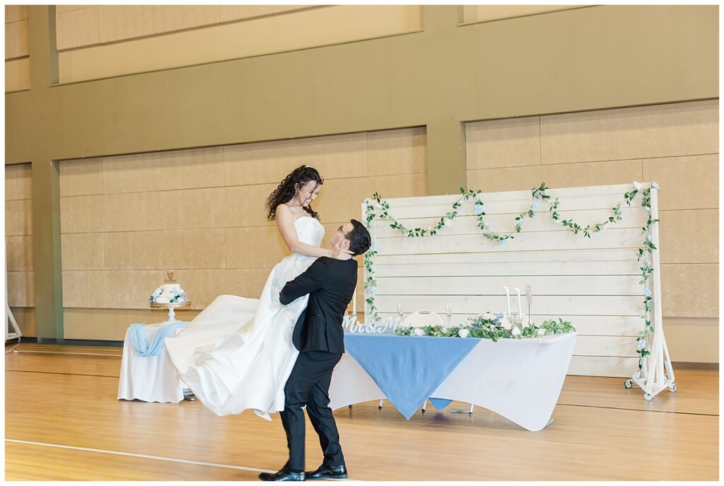 Groom lifts bride joyfully during their first dance at reception — Zoe Evans Photography