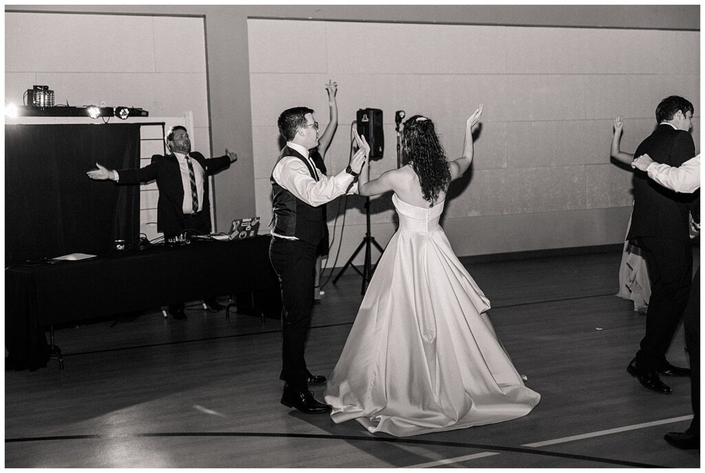 Black and white photo of bride and groom dancing at their wedding reception