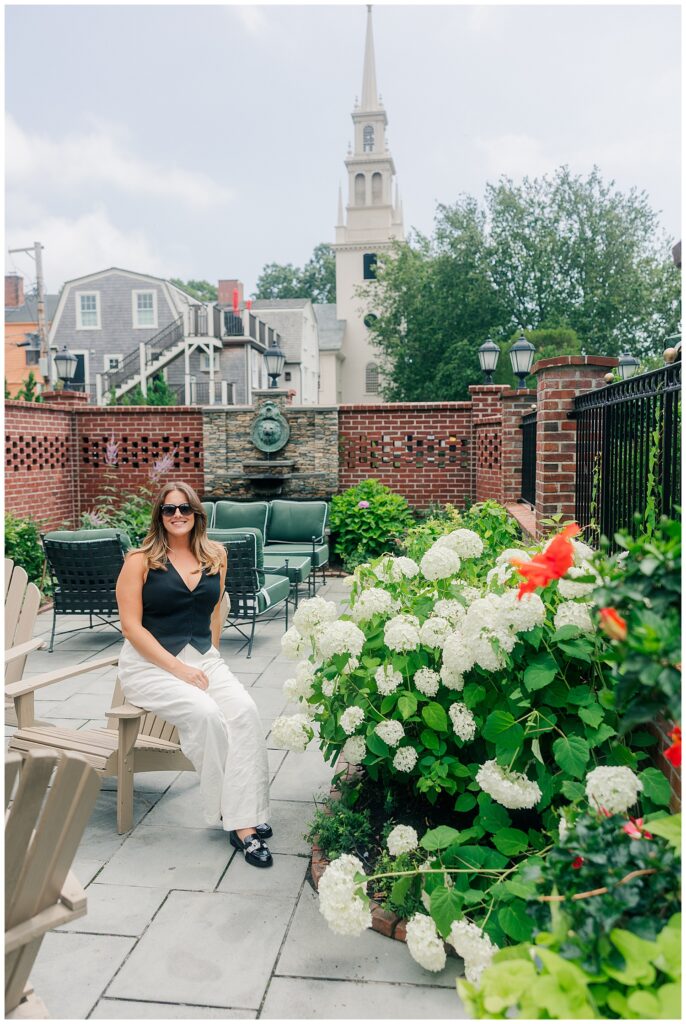 Travel advisor Lauren captured in a chic garden courtyard during her brand session, showcasing her relaxed, luxury lifestyle vibe. Photo by Zoe Evans Photography.