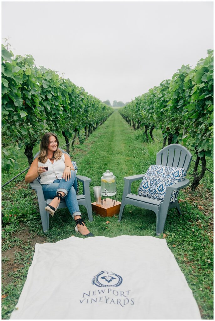 Travel advisor brand photo of Lauren relaxing with a glass of wine at a vineyard during her branding session with Zoe Evans Photography in Newport, Rhode Island.