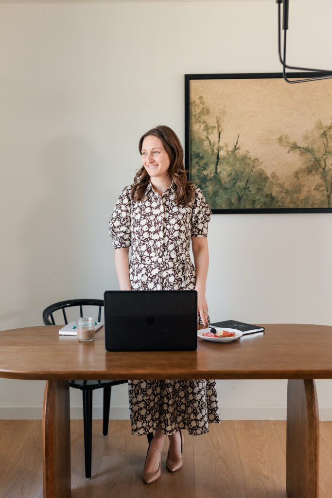 Creative business owner standing at her desk during a lifestyle branding session – modern brand photos by Zoe Evans Photography for entrepreneurs.