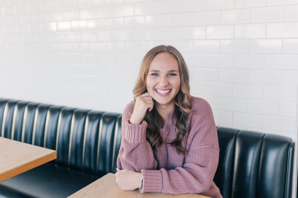 Woman sitting in a café booth during her lifestyle brand session – branding photography for entrepreneurs by Zoe Evans Photography. Book yours today.