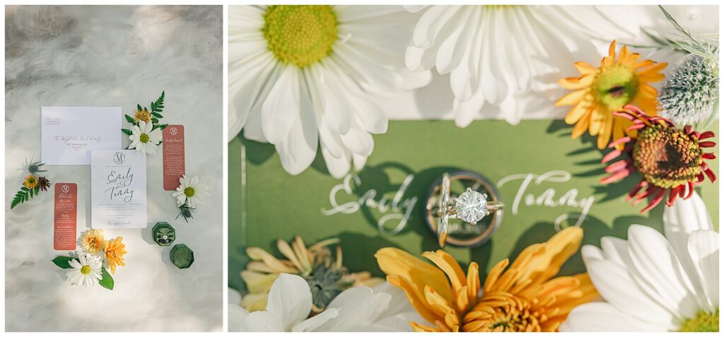 Close-up flat lay of wedding rings placed on a sage green invitation card, surrounded by white daisies and yellow florals for a fresh, spring-inspired detail shot.