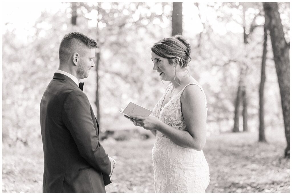 Black and white photo of bride reading vows during private ceremony moment in West Virginia