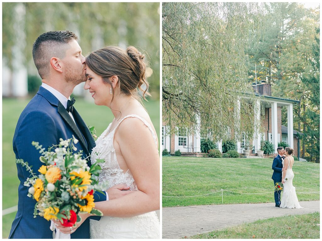 Groom kisses bride’s forehead while she holds a vibrant fall bouquet, with willow trees and the historic estate behind them.