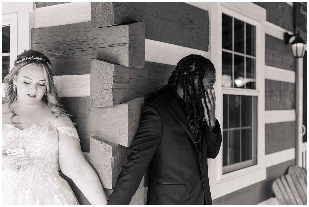 Groom and Bridge doing first touch in front of a rustic wood cabin before his wedding at Palomino Pastures, a scenic West Virginia venue.