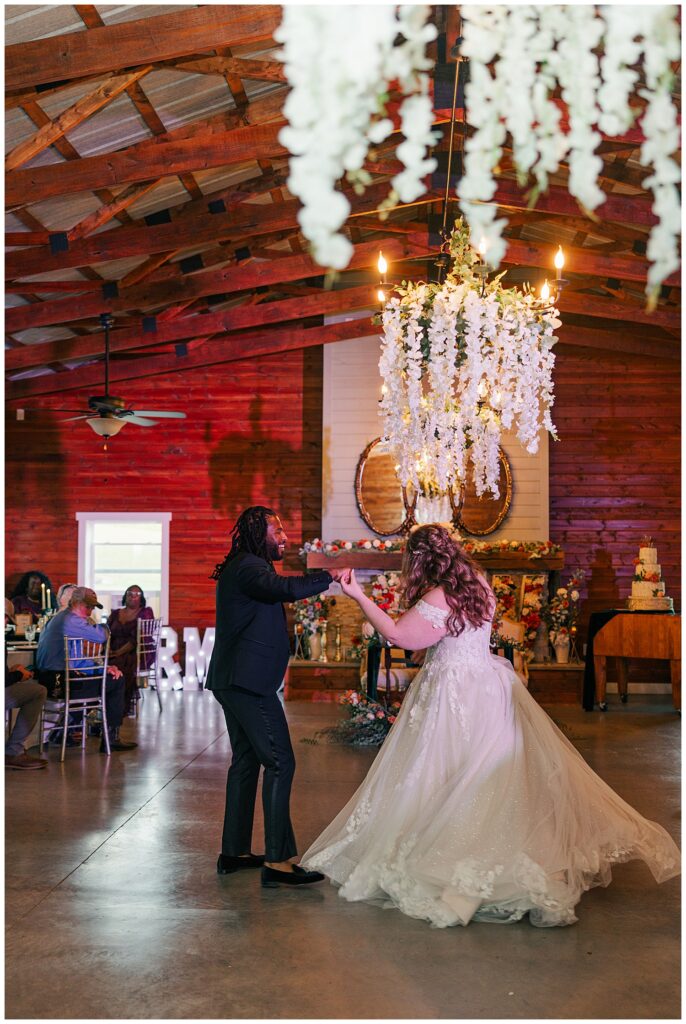 Groom twirls the bride during first dance. Pastures wedding in Ritchie County, WV. Shot by Zoe Evans Photography.