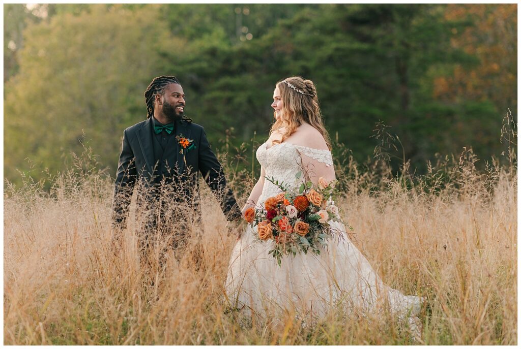 Groom looking at bride lovingly while standing in a field surrounded by autumn tones at Palomino Pastures wedding in West Virginia, photography by Zoe Evans Photography