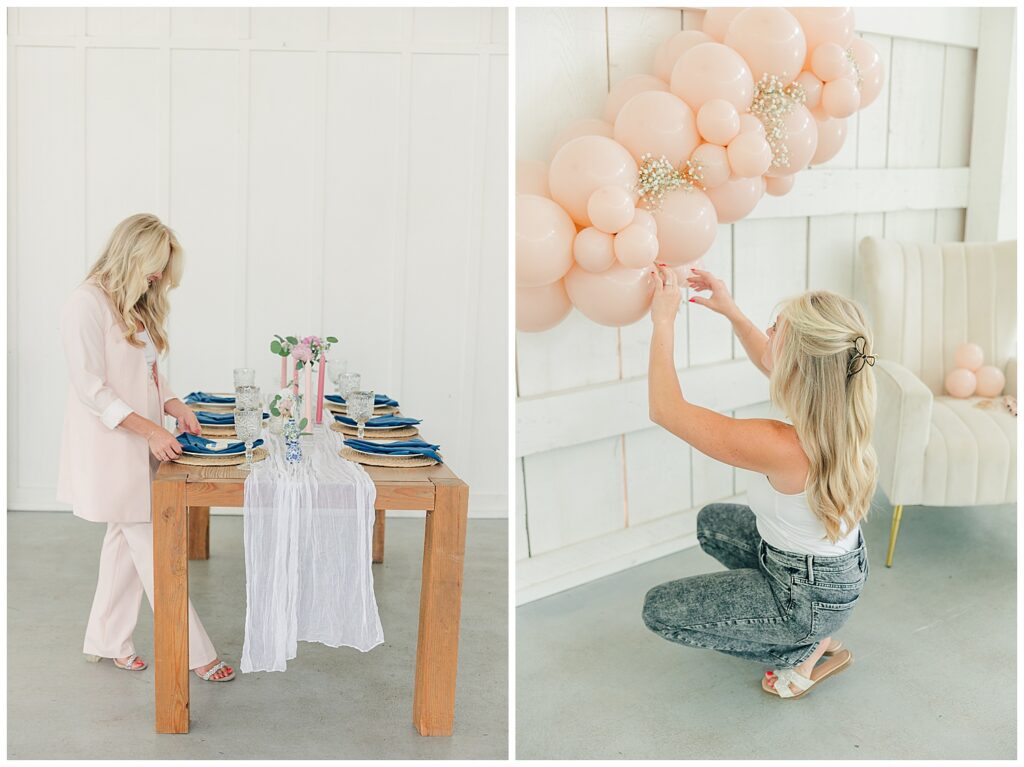 Behind-the-scenes brand photo of a woman styling a wooden table with florals, books, and linens in a bright, white event space. Brand photo of a woman on the floor styling peach balloons on a white shiplap wall for a creative or event-planning business.