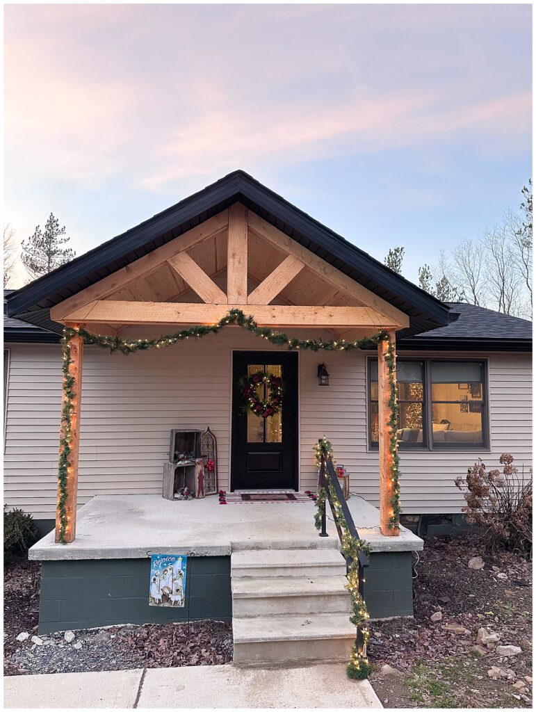 Front porch view of renovated home with cedar gable and lights – a personal update from Zoe Evans’ 2025 recap.
