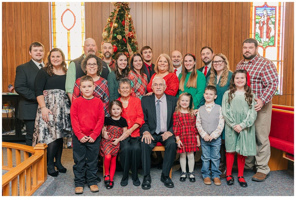 Large multi-generational family portrait taken indoors during a holiday photo session.