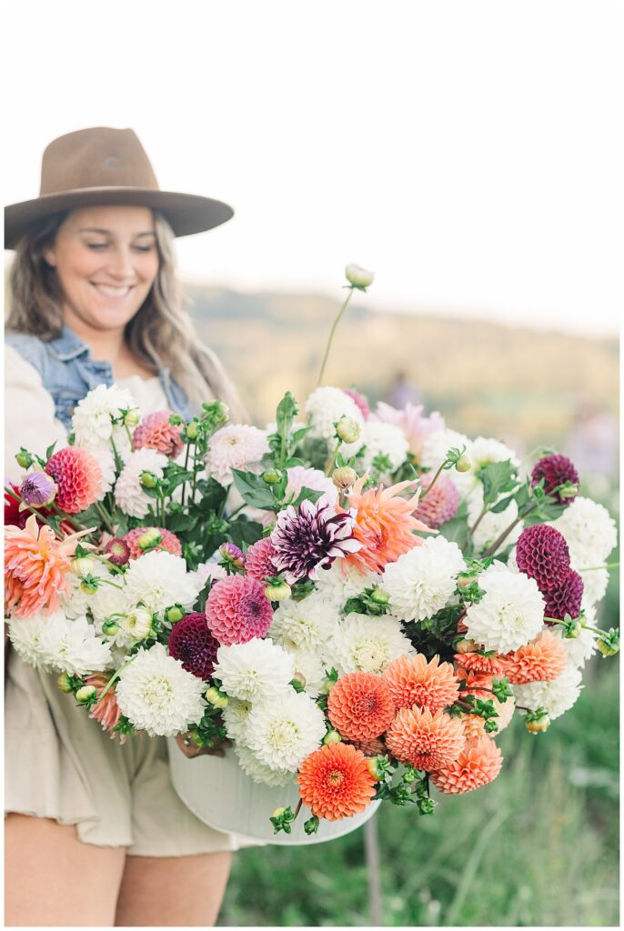 Female business owner smiling with a colorful bouquet, showing how vibrant visuals support connection when paired with a clear brand message.