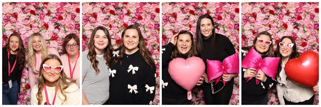 Women entrepreneurs posing in front of a pink floral backdrop with heart balloons at a Galentine’s branding event for small business owners.