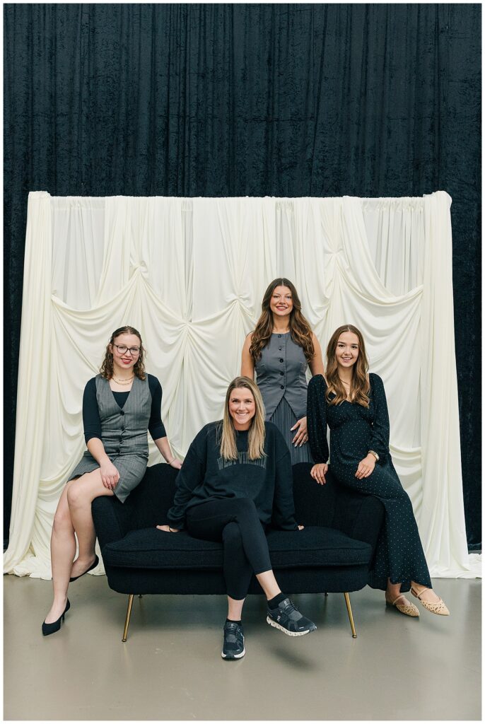 Team branding photo of Brittany Ann’s Events team posing on a black couch at The Onyx Room West Virginia during a business branding session in Morgantown WV