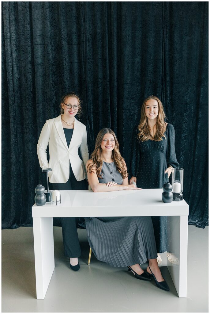 Team branding photo of Brittany Ann’s Events group posing together at a desk during a session at The Onyx Room West Virginia in Morgantown WV