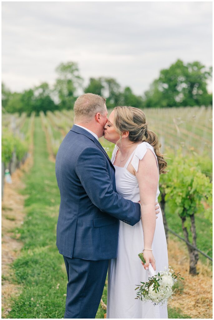 Bride and groom sharing a kiss among the vineyards during a Williams Gap Winery elopement in Virginia